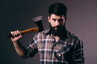 Tıraş balta ile. Kendine güvenen genç sakallı adam büyük bir balta taşıyan