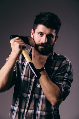 Tıraş balta ile. Kendine güvenen genç sakallı adam büyük bir balta taşıyan