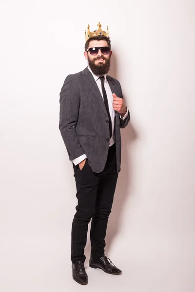 Young handsome man in sunglasses wearing suit and crown — Stock Photo, Image