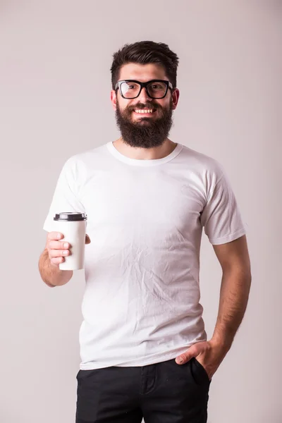 Sakallı genç adam kahve fincanı ve gülümseyen — Stok fotoğraf