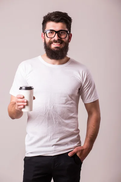 Kahve kamera bakmak el ile sakallı genç adam — Stok fotoğraf