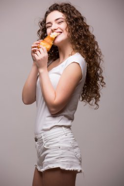 gri bir kruvasan yemek çekici kıvırcık kadın