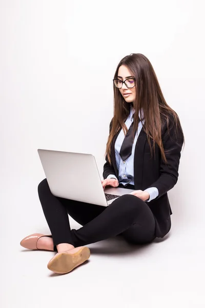 Giovane donna che lavora sul suo computer portatile, seduta sul pavimento — Foto Stock
