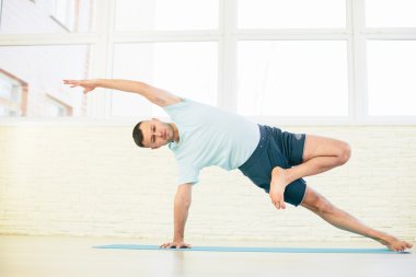 Bir eğitim salonu alýþtýrmalarda Atractive yoga çift, erkek ve kadın, pratik