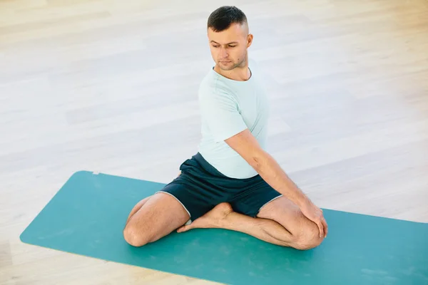 Atractive yoga couple , man and woman, practice exercises in a training hall