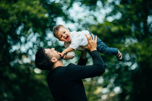 Gelukkig vreugdevolle vader die plezier gooit omhoog in de lucht — Stockfoto