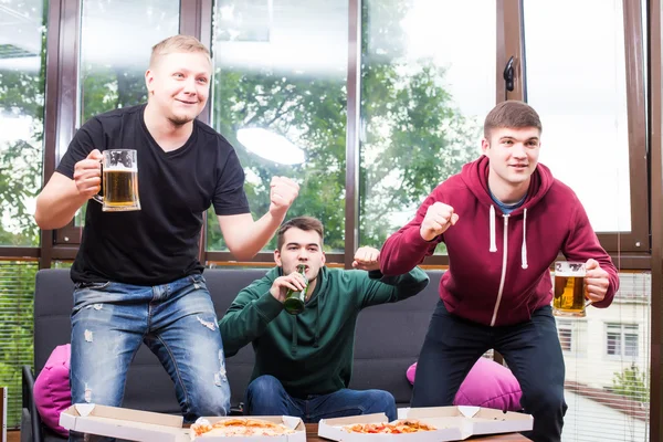 Amigos masculinos sonrientes jugando videojuegos, beber cerveza y divertirse en casa —  Fotos de Stock
