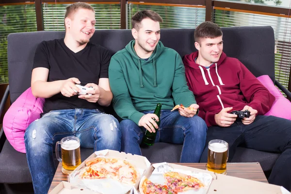 Three happy young men watching football game and keeping arms raised — Stock Photo, Image