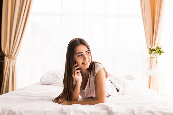 젊은 여 자가 그녀의 침대에서 집에 전화 — 스톡 사진