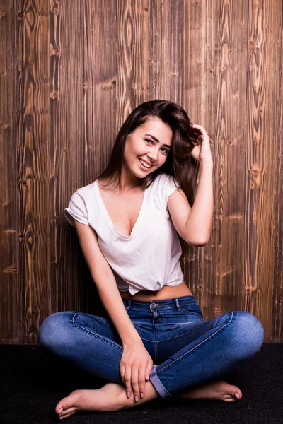 Dziewczyny w dżinsy i koszulę drewnianą ścianę — Zdjęcie stockowe