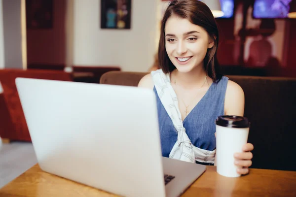 Kobieta pracuje na laptopie w kawiarni — Zdjęcie stockowe