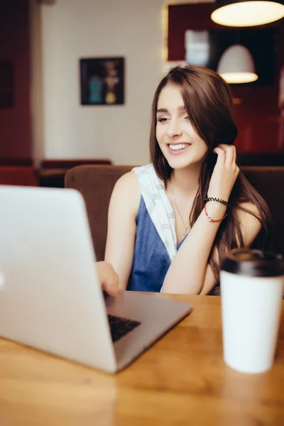 Vrouw die op laptop in coffeeshop werkt — Stockfoto