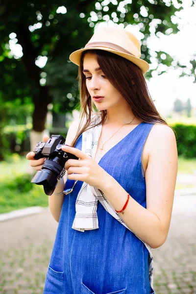 Молодая девушка развлекается в городе с фотоаппаратом путешествия фото фотографа — стоковое фото