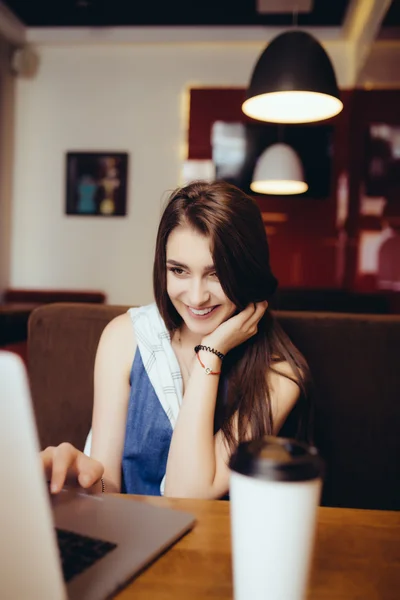 Vrouw die op laptop werkt en praten over de telefoon in de coffeeshop — Stockfoto