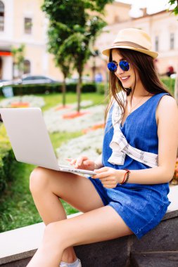 Güzel kız şehir sokak merdivenlerde oturan dizüstü bilgisayar ile çalışma.