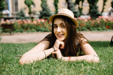 çimenlerin üzerinde yaz günü şehir parkında yalan güneş gözlüklü kız