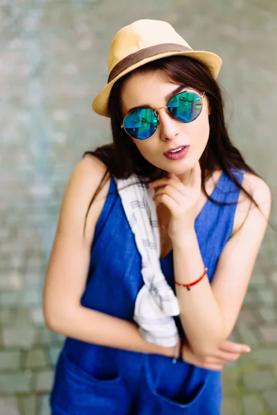 모자와 선글라스를 입고 예쁜 젊은 앉아있는 소녀의 초상화 — 스톡 사진