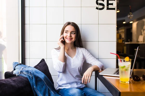 Mulher falando no telefone celular com amigo enquanto sentado sozinho no interior moderno café — Fotografia de Stock