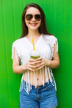  limonata ya da taze güneş gözlüğü ve şapka mavi renkli arka plan üzerinde olan kadın