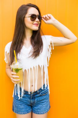 güneş gözlüğü ve şapka renk arka plan üzerinde içki Kupası kadınla