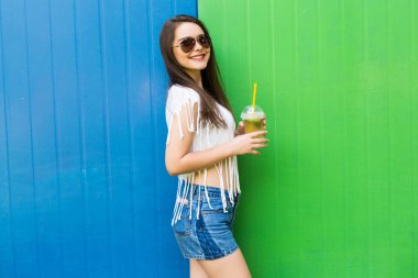 güneş gözlüğü ve şapka renk arka plan üzerinde içki Kupası kadınla