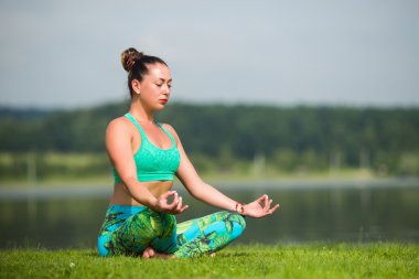 Yoga kız eğitim açık havada doğa arka plan üzerinde. Yoga kavramı.
