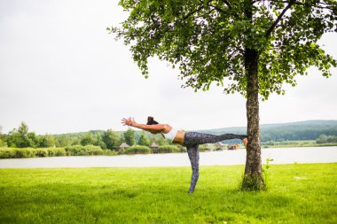 Yoga kız eğitim açık havada doğa arka plan üzerinde. Yoga kavramı.