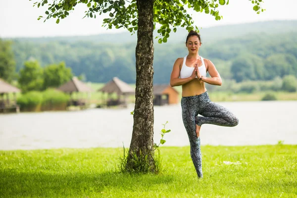 Yoga-Mädchen, die im Freien vor dem Hintergrund der Natur trainieren. Yoga-Konzept. — Stockfoto