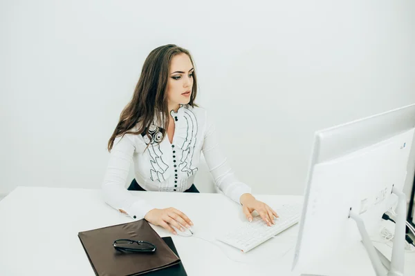 女性のオフィスで、机に座って作業コンピューターを使用して — ストック写真