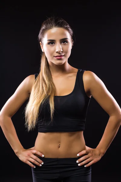 Beautiful young woman with a sexy body in a sports bra and black