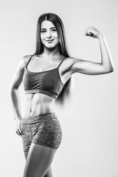 Atlético jovem mulher mostrando músculos de mãos — Fotografia de Stock