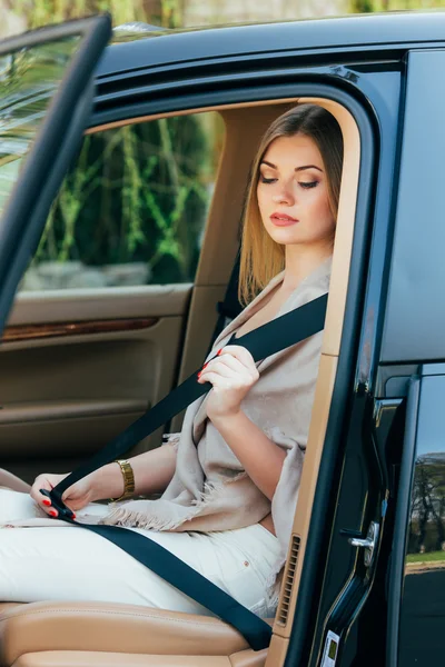 Mujer abrocharse el cinturón de seguridad en un coche — Foto de Stock