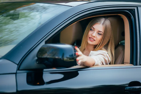 Девушка в машине устраивает зеркало — стоковое фото
