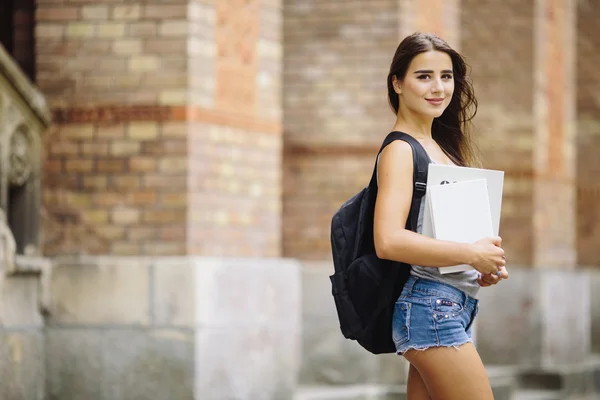 Sorrindo menina da faculdade está segurando livro — Fotografia de Stock