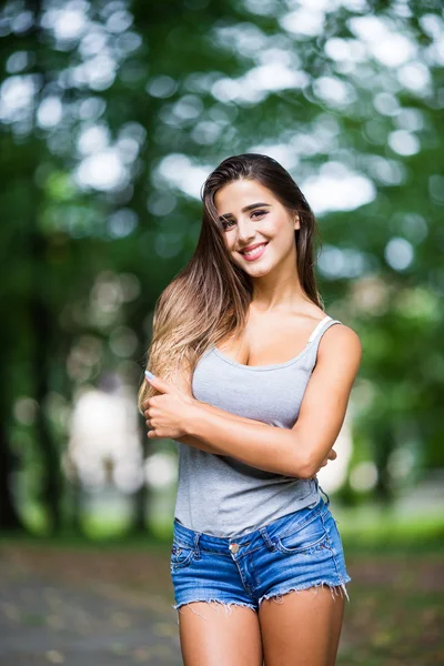 Beautiful young woman walking in summer park — Stock Photo, Image