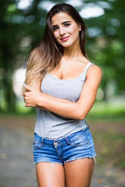 Mooie jonge vrouw wandelen in zomerpark — Stockfoto