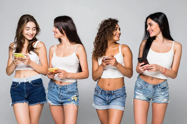 Quatro Mulheres Com Telefone Olhando Umas Outras Fundo Branco — Fotografia de Stock