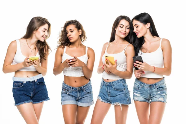 Młoda Czwórka Kobiet Koszulach Szortach Stojąca Telefonami Dłoniach Białym Tle — Zdjęcie stockowe