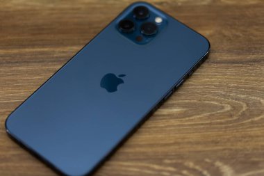 Chernivtsi, Ukrayna - Mart 2021: Apple iphone 12 Pro Max mavi akıllı telefon ofisteki beyaz ahşap bir masada