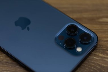 Chernivtsi, Ukrayna - Mart 2021: Apple iphone 12 Pro Max mavi akıllı telefon ofisteki beyaz ahşap bir masada