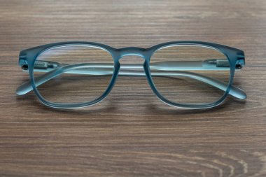 Ahşap masadaki gözlüklü mavi renk.