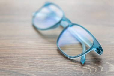 Ahşap masadaki gözlüklü mavi renk.