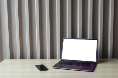 bilgisayar beyaz boş ekran ve telefon çalışma masasında.