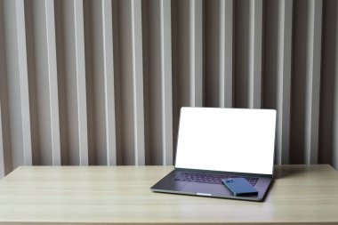 bilgisayar beyaz boş ekran ve telefon çalışma masasında.