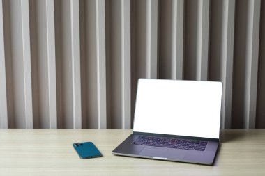 bilgisayar beyaz boş ekran ve telefon çalışma masasında.