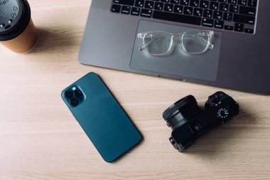 Akıllı telefon, defter, kamera gözlüğü ve kahve ile yatıyordu.