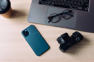 Akıllı telefon, defter, kamera gözlüğü ve kahve ile yatıyordu.