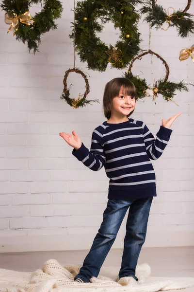 Yakışıklı çocuk Noel arka plan üzerinde oyuncak ile