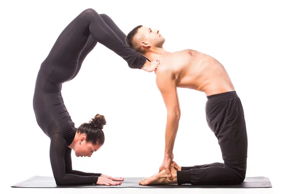 Jeune couple en bonne santé en position de yoga sur fond blanc — Photo