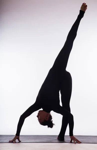 Unga vackra yoga kvinna poserar på en studio bakgrund — Stockfoto